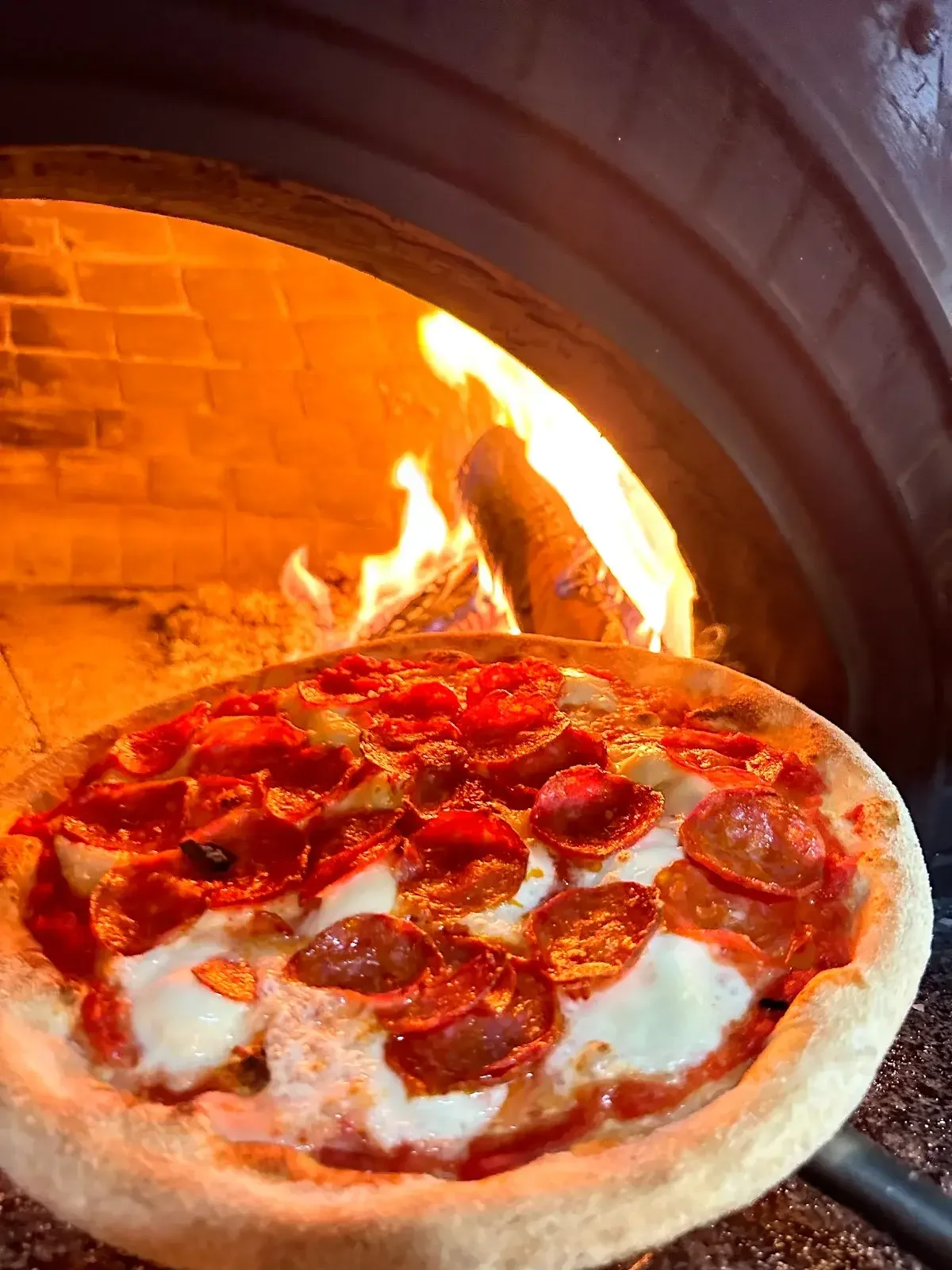 Pizza de pepperoni saliendo del horno