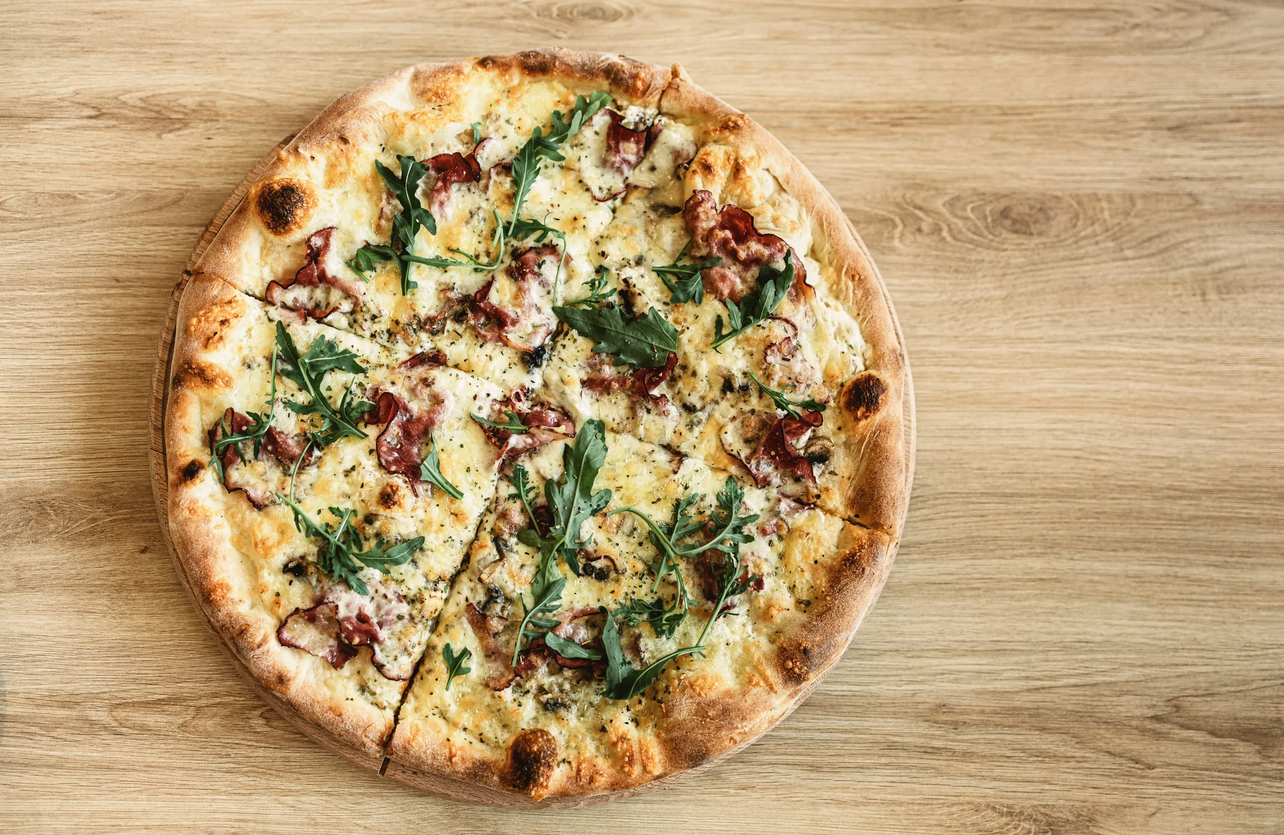 Pizza bianca con rúcula y panceta